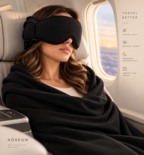 Woman asleep in a plane window seat wearing the Norrow sleep mask and wrap